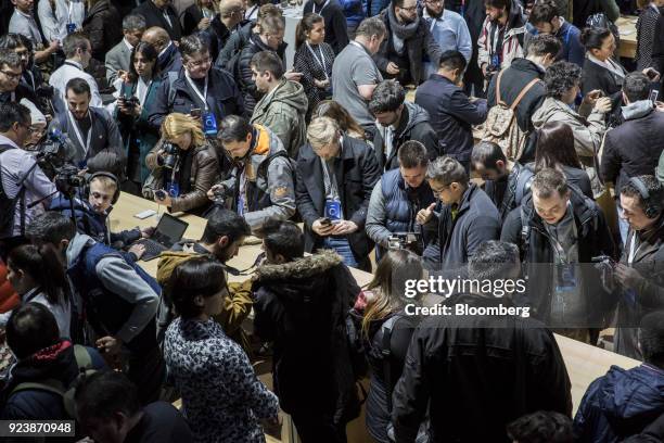 Attendees inspect Alcatel smartphone devices on display during an Alcatel-Lucent SA launch event ahead of the Mobile World Congress in Barcelona,...