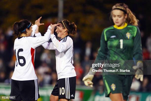 Hasret Kayicki and Ramona Petzelberger of Germany celebrate their teams first goal while Hilda Carlen of Sweden looks dejected during the women's...