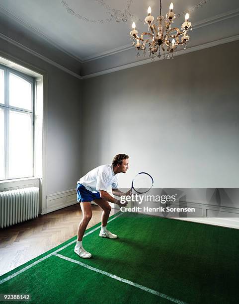 male tennis player on indoor court in room - man made structure stock pictures, royalty-free photos & images