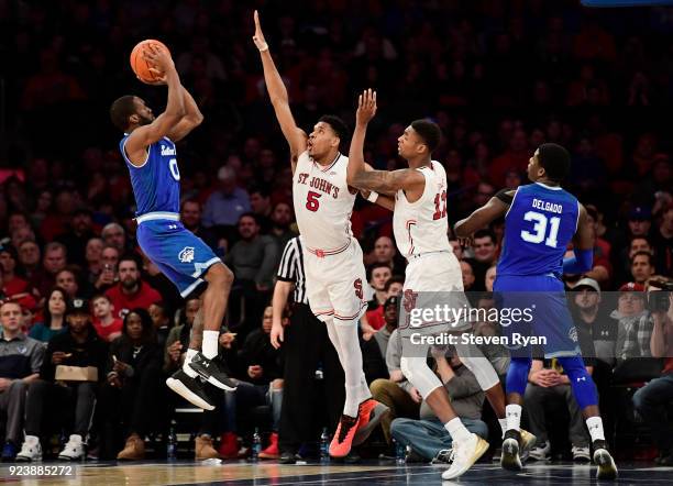Khadeen Carrington of the Seton Hall Pirates defended by Justin Simon and Tariq Owens of the St. John's Red Storm during the second half an NCAA...