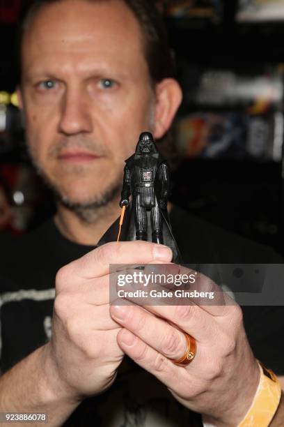 Robert Weidenfeld of Vegas Toy Squad holds up a rare Darth Vader action figure with a double-telescoping lightsaber during Vegas Toy Con at the...