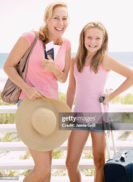 mother and daughter holding passports and luggage - shoulder bag stock pictures, royalty-free photos & images