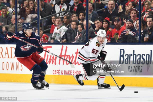 Tommy Wingels of the Chicago Blackhawks skates the puck away from Alexander Wennberg of the Columbus Blue Jackets during the second period of a game...