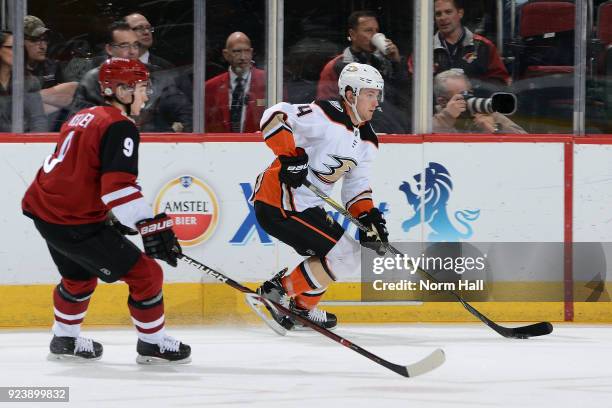 Cam Fowler of the Anaheim Ducks skates with the puck ahead of Clayton Keller of the Arizona Coyotes during the first period at Gila River Arena on...