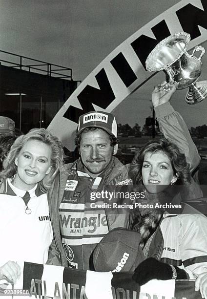 Dale Earnhardt holds the winning tropy after edging out Bill Elliott for the win on November 11, 1984.
