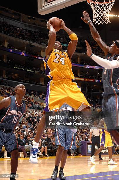 Kobe Bryant of the Los Angeles Lakers goes to the basket against Raja Bell and Gerald Wallace of the Charlotte Bobcats during the preseason game on...