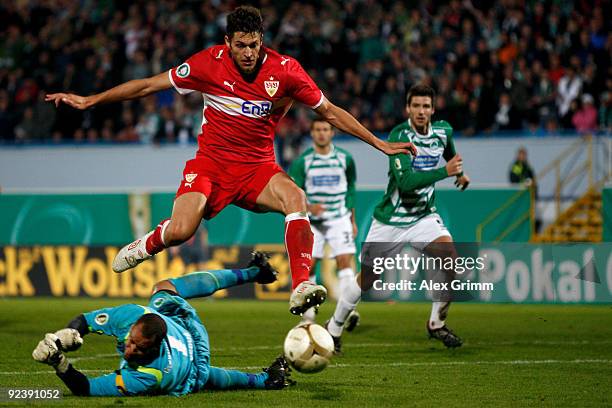 Matthieu Delpierre of Stuttgart jumps over goalkeeper Stephan Loboue of Greuther Fuerth during the DFB Cup match between SpVgg Greuther Fuerth and...