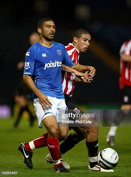 Hayden Mullins of Portsmouth gets tackled by Diego Arismendi of Stoke City during the Carling Cup fourth round match between Portsmouth and Stoke...