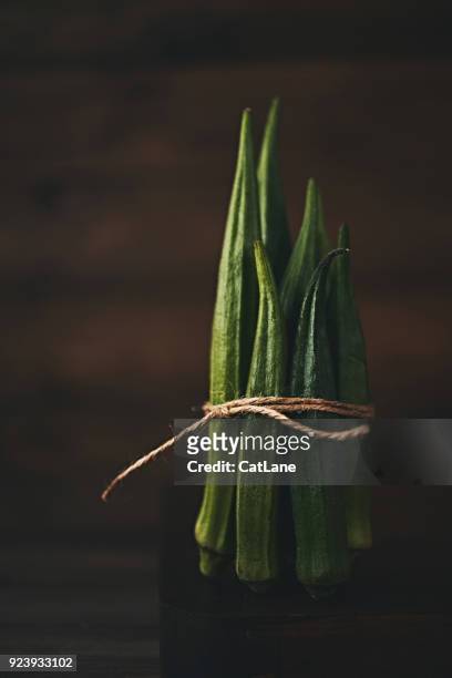 still life of bundled okra shot in dark moody light - okra stock pictures, royalty-free photos & images