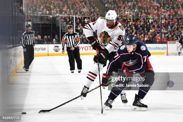 Anthony Duclair of the Chicago Blackhawks and Josh Anderson of the Columbus Blue Jackets battle for a loose puck during the third period of a game on...
