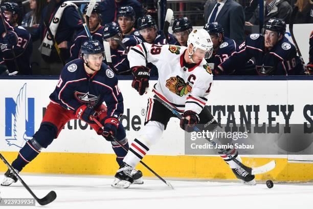 Jonathan Toews of the Chicago Blackhawks keeps the puck from Alexander Wennberg of the Columbus Blue Jackets during the third period of a game on...