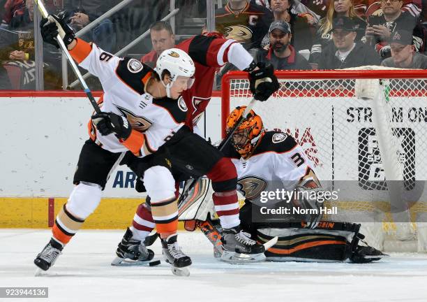 Goalie Ryan Miller of the Anaheim Ducks looks for the puck as Christian Dvorak of the Arizona Coyotes and Brandon Montour of the Ducks battle in...