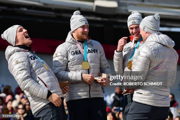 Gold medallists Germany's Thorsten Margis, Martin Grothkopp, Germany's Candy Bauer and Germany's Francesco Friedrich laugh on the podium after the...