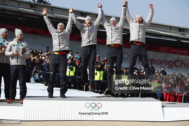 Gold medalists Francesco Friedrich, Candy Bauer, Martin Grothkopp and Thorsten Margis of Germany celebrate on the podium during the medal ceremony...