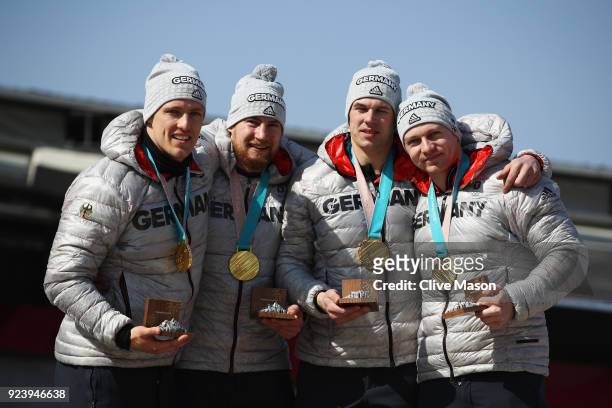 Gold medalists Francesco Friedrich, Candy Bauer, Martin Grothkopp and Thorsten Margis of Germany celebrate on the podium during the medal ceremony...