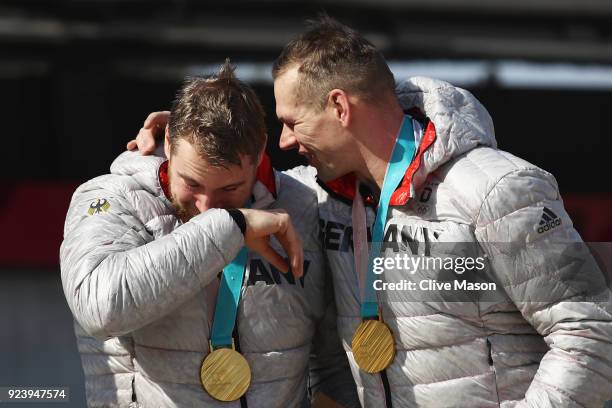 Gold medalists Candy Bauer and Martin Grothkopp of Germany celebrate on the podium during the medal ceremony after the 4-man Boblseigh Heats on day...