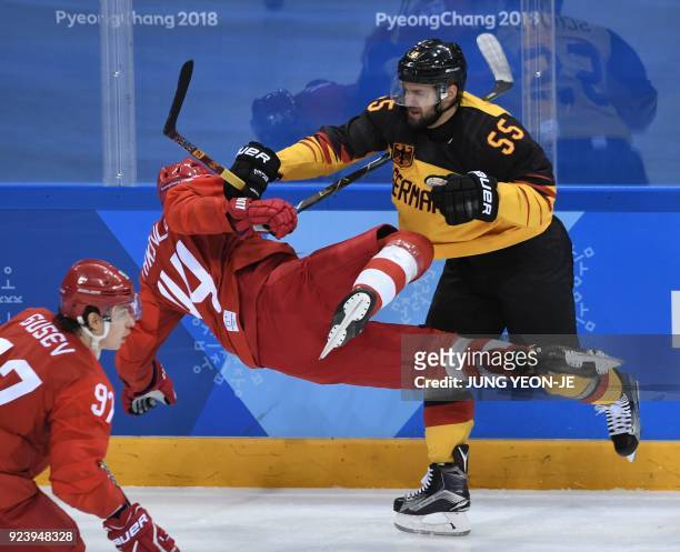 Germany's Felix Schutz adn Russia's Yegor Yakovlev clash in the men's gold medal ice hockey match between the Olympic Athletes from Russia and...