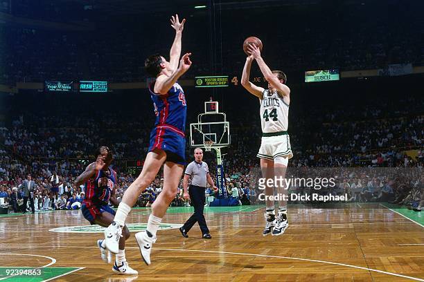 Danny Ainge of the Boston Celtics shoots a jump shot against Bill Laimbeer of the Detroit Pistons during a game played in 1987 at the Boston Garden...