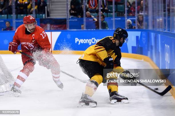 Russia's Pavel Datsyuk and Germany's Felix Schutz fight for the puck in the men's gold medal ice hockey match between the Olympic Athletes from...