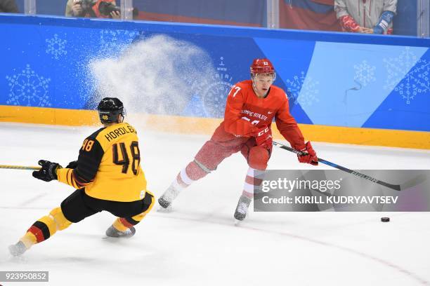 Germany's Frank Hordler and Russia's Kirill Kaprizov fight for the puck in the men's gold medal ice hockey match between the Olympic Athletes from...
