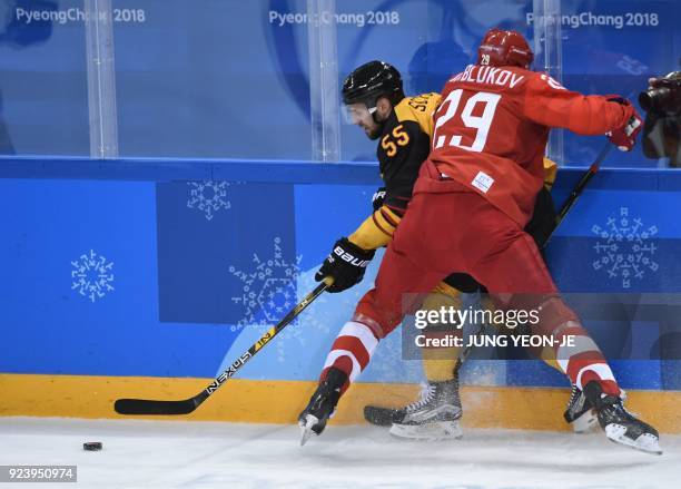 Germany's Felix Schutz tries to get past Russia's Ilya Kablukov in the men's gold medal ice hockey match between the Olympic Athletes from Russia and...