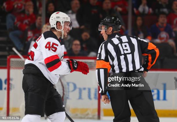 Sami Vatanen of the New Jersey Devils talks with referee Gord Dwyer against the New York Islanders during the game at Prudential Center on February...