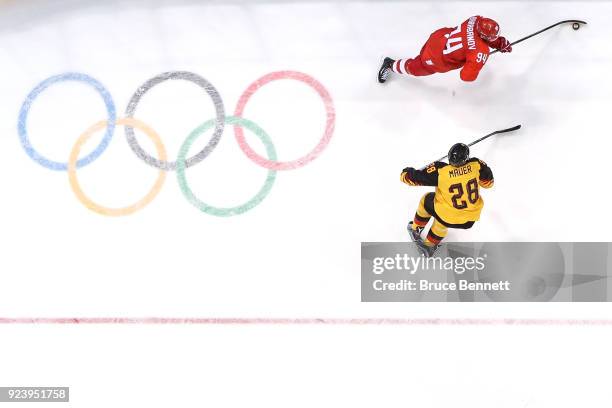 Alexander Barabanov of Olympic Athlete from Russia controls the puck against Frank Mauer of Germany in the first period during the Men's Gold Medal...