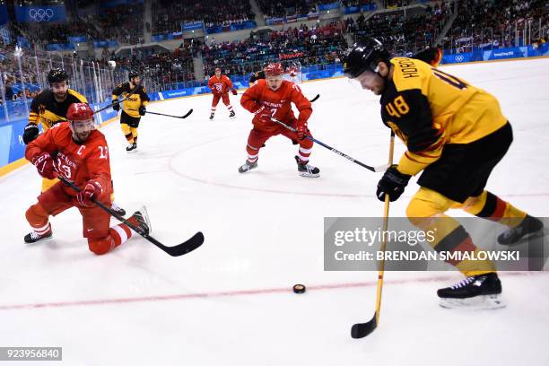 Russia's Pavel Datsyuk and Germany's Frank Hordler fight for the puck in the men's gold medal ice hockey match between the Olympic Athletes from...