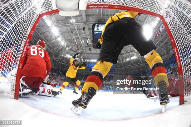 Brooks Macek and Patrick Hager of Germany celebrate after a goal by teammate Felix Schutz in the second period against Vasili Koshechkin of Olympic...