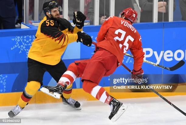 Germany's Felix Schutz clashes with Russia's Vyacheslav Voinov in the men's gold medal ice hockey match between the Olympic Athletes from Russia and...