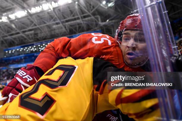 Germany's Brooks Macek and Russia's Bogdan Kiselevich collide in the men's gold medal ice hockey match between the Olympic Athletes from Russia and...