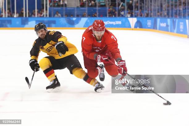 Ivan Telegin of Olympic Athlete from Russia controls the puck against Yannic Seidenberg of Germany in the third period during the Men's Gold Medal...