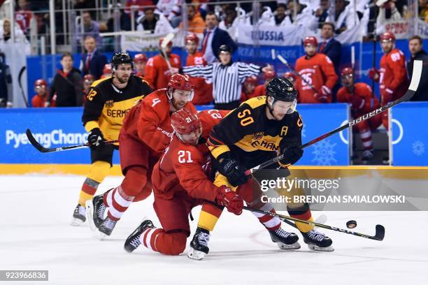 Germany's Patrick Hager fights for the puck with Russia's Vladislav Gavrikov and Sergei Kalinin in the men's gold medal ice hockey match between the...