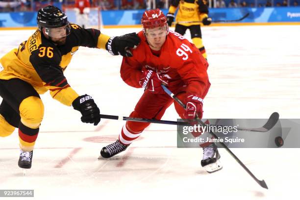 Alexander Barabanov of Olympic Athlete from Russia competes for the puck against Yannic Seidenberg of Germany in overtime during the Men's Gold Medal...
