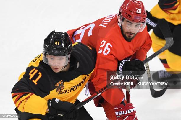 Germany's Jonas Muller and Russia's Vyacheslav Voinov fight for the puck in the men's gold medal ice hockey match between the Olympic Athletes from...