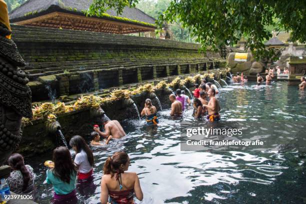 tourists bathing in the holy water at pura tirta empul temple, tampaksiring, bali, indonesia - tirta empul temple stock pictures, royalty-free photos & images