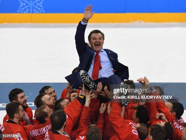 Oleg Znarok,coach for gold medal winners the Olympic Athletes from Russia, is lifted up during the medal ceremony after the men's gold medal ice...