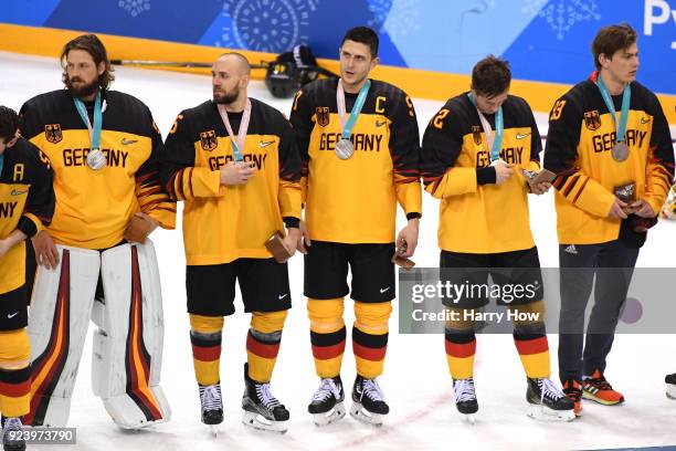 Silver medal winners Timo Pielmeier, Felix Schutz, Marcel Goc, Dominik Kahun and Leonhard Pfoderl of Germany look on during the medal ceremony after...