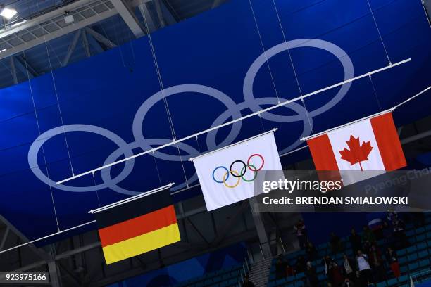 The Olympic flag is raised for the gold medallists from the Olympic Athletes from Russia between the flags for Germany and Canada during the medal...