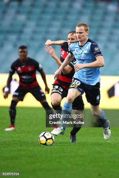 Matt Simon of Sydney FC runs the ball under pressure from Michael Thwaite of the Wanderers during the round 21 A-League match between Sydney FC and...