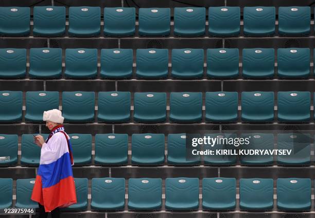 Fan of Russia checks her phone after the medal ceremony in the men's gold medal ice hockey match between the Olympic Athletes from Russia and Germany...