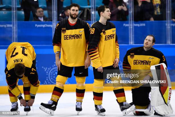 Germany's players wait to receive their silver medals on the podium during the medal ceremony after the men's gold medal ice hockey match between the...