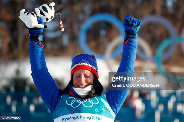 Norway's Marit Bjoergen celebrates her gold win on the podium during the venue ceremony for the women's 30km cross country mass start classic at the...