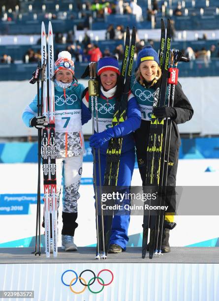 Second placed Krista Parmakoski of Finland, first placed Marit Bjoergen of Norway and third placed Stina Nilsson of Sweden celebrate following the...