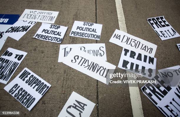 Placards reading "stop political persecution" and "we support press freedom" lie on a road along with other slogans during a protest against...