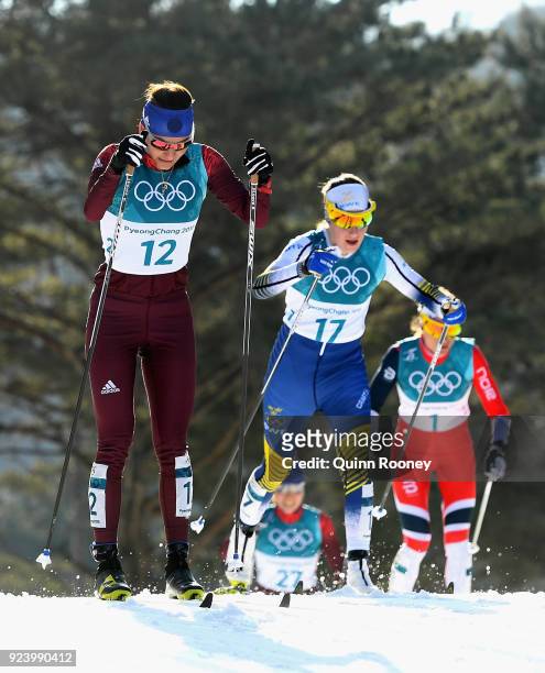 Anastasia Sedova of Olympic Athlete from Russia and Ebba Andersson of Sweden compete during the Ladies' 30km Mass Start Classic on day sixteen of the...