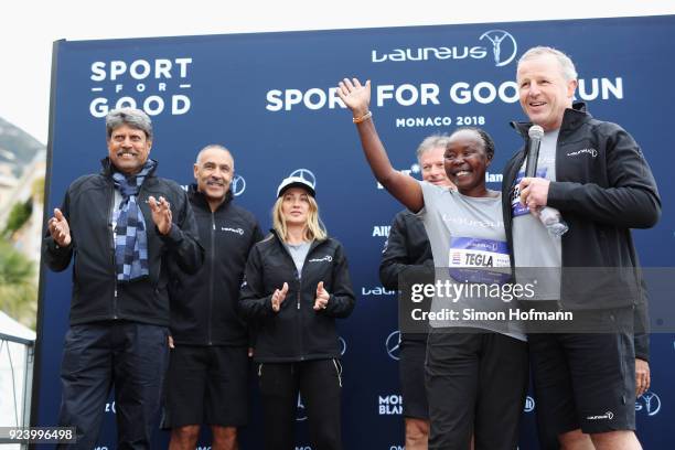 Laureus Academy Chairman Sean Fitzpatrick speaks as Laureus Academy Member Tegla Loroupe waves with other Laureus Academy members Kapil Dev,Daley...