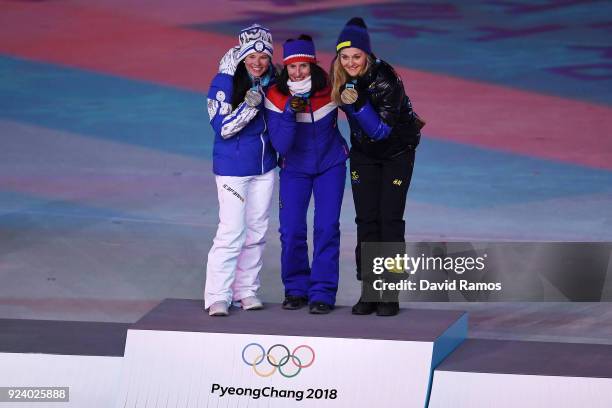 Silver medalist Krista Parmakoski of Finland, gold medalist Marit Bjorgen of Norway and bronze medalist Stina Nilsson of Sweden poses during the...