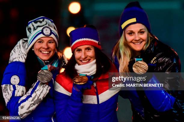 Finland's silver medallist Krista Parmakoski, Norway's gold medallist Marit Bjoergen and Sweden's bronze medallist Stina Nilsson pose on the podium...