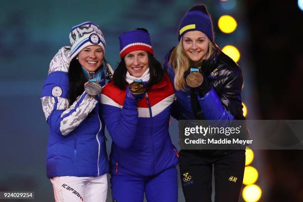 Silver medalist Krista Parmakoski of Finland, gold medalist Marit Bjorgen of Norway and bronze medalist Stina Nilsson of Sweden poses during the...